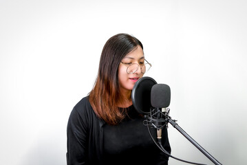 Beautiful asian woman (LGBTQ) is a singer. She enjoying sing a song or karaoke in music studio with...