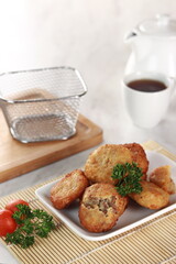 fried potato cheese balls croquettes with tomato ketchup served in a basket. white background and garnish