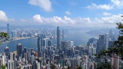 Panoramic Aerial View of Hong Kong Skyline and Victoria Harbour with Dense Skyscrapers, Boats, and...