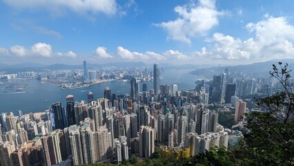 Panoramic Aerial View of Hong Kong Skyline and Victoria Harbour with Dense Skyscrapers, Boats, and...