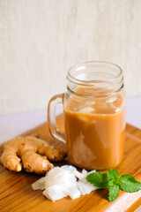 glass mug of hot ginger drink while wrapped in blanket. Close up shot