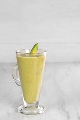 Avocado juice with avocado pieces. served in a very luxurious clear glass. isolated in white background