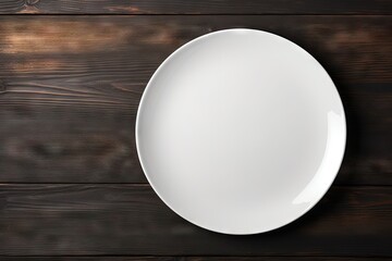 Top view of an empty white plate on a black table background Copy space available