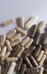 large beige, white and brown medicine capsules and pills on a white background. Supplements, vitamins and healthcare. 