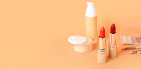 Cosmetic products and lipsticks on beige background with space for text