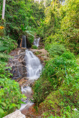 beautiful cascading waterfall over rocks long exposure in Chiangmai Chiang mai mountains northern thailand amongst lush green tropical rainforest