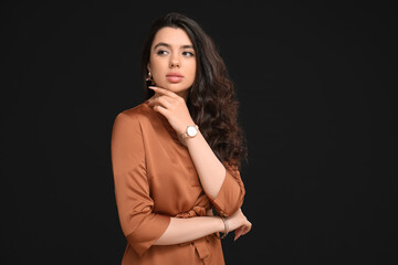 Naklejka premium Elegant beautiful woman with wristwatch on black background
