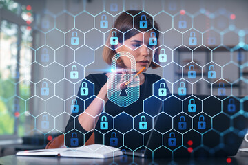 Pensive attractive beautiful businesswoman in formal wear working on laptop at office workplace in...