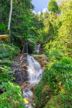 beautiful cascading waterfall over rocks long exposure in Chiangmai Chiang mai mountains northern thailand amongst lush green tropical rainforest