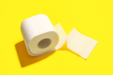 Roll of toilet paper on yellow background