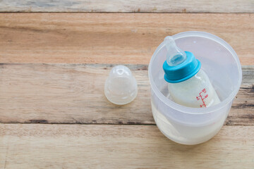 bottle milks of baby suck on water for warm arrangement flat lay style on background wooden