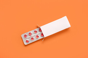 Yellow pills in blister pack on orange background