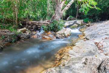Naklejka na ściany i meble beautiful cascading waterfall over rocks long exposure in Chiangmai Chiang mai mountains northern thailand amongst lush green tropical rainforest