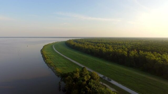 Aerial Shot Of Pickup Truck Towing Boat In Meadow By Tranquil River Against Sky - Bayou, Louisiana