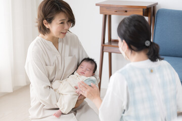 新生児や乳幼児の1ヶ月訪問をうける母親　心配で相談する赤ちゃん訪問の様子