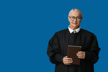 Mature female judge with book on blue background