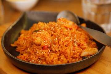 Shrimp Kimchi Fried Rice Served on a Korean style hot plate. Close up, on the wood table