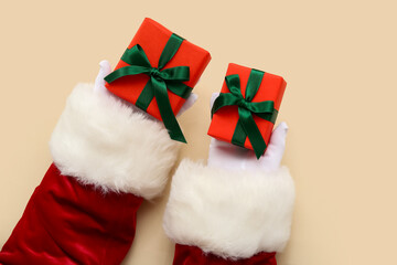 Obraz na płótnie Canvas Santa Claus with gift boxes on beige background