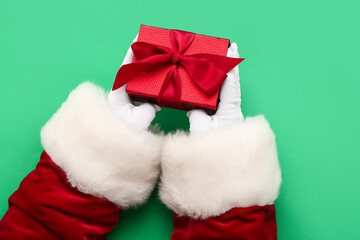 Obraz na płótnie Canvas Santa Claus with red gift box on green background