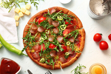 Delicious pizza with tomatoes and arugula on light blue background