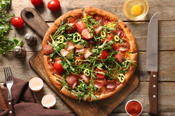 Board of delicious pizza with tomatoes and arugula on wooden background - obrazy, fototapety, plakaty