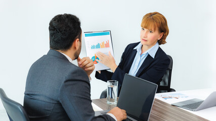 Business woman showing document to business man, professionals discussing papers working in office at meeting.