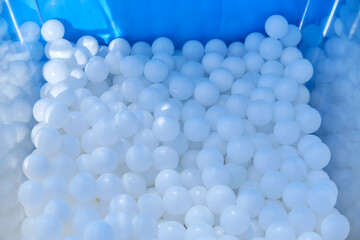 Foam balls in blue bucket, closeup of photo.