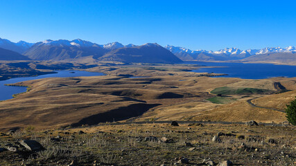 Beautiful blue sky with mountain range, Mount John observatory, south island, New Zealand. On the top of Mount John with scenic of lake Tekapo and lake alexandrina in turquoise.