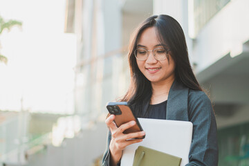 Confident businesswoman using mobile smart phone and working online