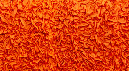 Orange silk crumpled fabric as an abstract background. Texture