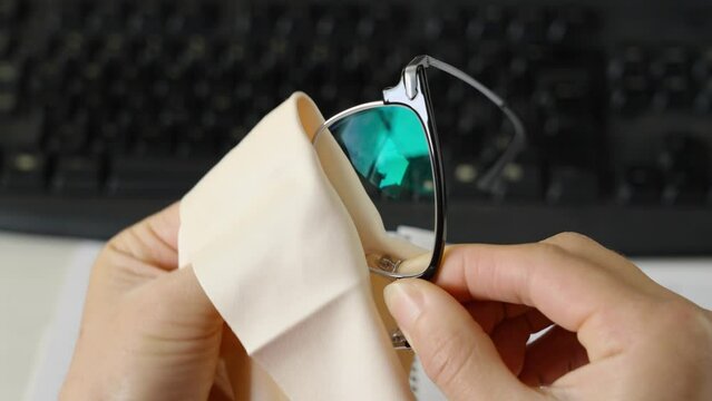 hand cleaning  black glasses lens with microfiber tissue. healthcare, vision and medicine concept