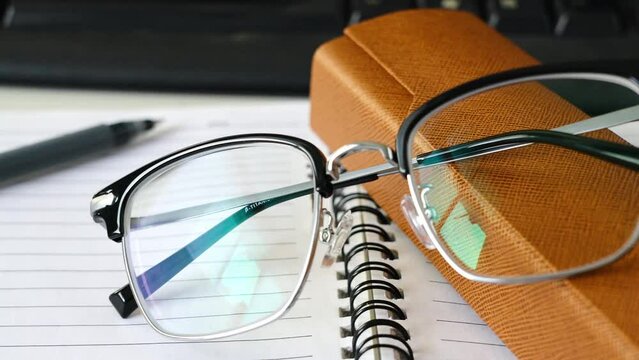 Stylish black glasses on desk