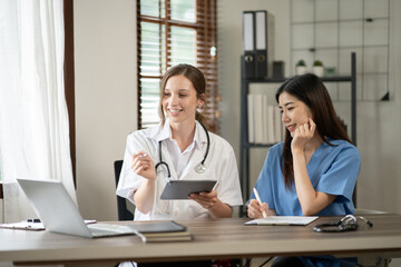 Female doctor sitting at work looking at the history of patients in the clinic or in the hospital