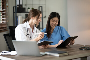 Obraz premium Female doctor sitting at work looking at the history of patients in the clinic or in the hospital