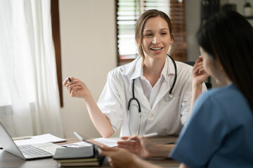 Female doctor sitting at work looking at the history of patients in the clinic or in the hospital