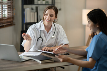 Obraz premium Female doctor sitting at work looking at the history of patients in the clinic or in the hospital