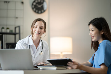 Obraz premium Female doctor sitting at work looking at the history of patients in the clinic or in the hospital