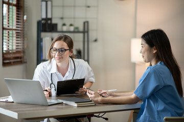 Obraz premium Female doctor sitting at work looking at the history of patients in the clinic or in the hospital