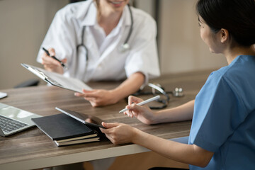 Obraz premium Female doctor sitting at work looking at the history of patients in the clinic or in the hospital