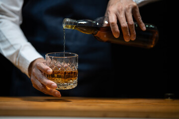 Fototapeta na wymiar Barman pouring whiskey whiskey glass..