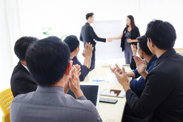 Businesspeople discussing at conference office desk, business team clapping hands to admire compliment during people reached agreement deal handshake, successful company teamwork meeting.