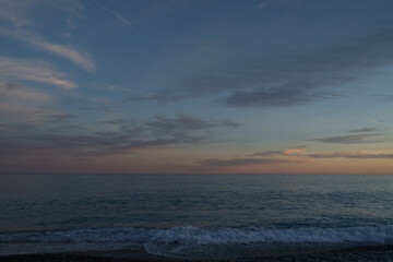 Sunset on the French Riviera pebble beach in Nice with straight horizon line