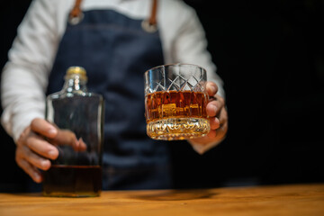 Bartender pours whiskey to customer in tavern