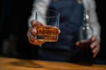 Bartender pours whiskey to customer in tavern