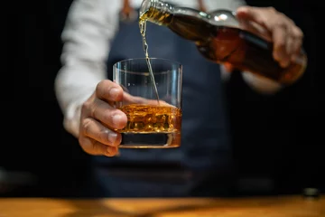 Fotobehang Bartender pours whiskey to customer in tavern © Thitisak