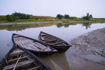 Obraz premium landscape view of Traditional wooden fishing boats on the shore of the Padma River in Bangladesh