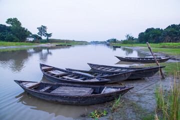 Naklejka na ściany i meble landscape view of Traditional wooden fishing boats on the shore of the Padma River in Bangladesh