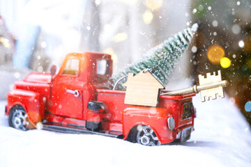 Red retro car with a Christmas tree decorates with the house key in the pickup truck for Christmas....
