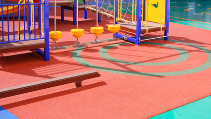 Playground climbing equipment with balance beams on colorful rubber floor in outdoors playground...