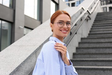 Portrait of beautiful woman in glasses outdoors, space for text